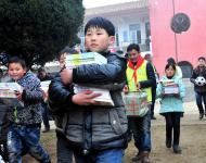 2016年1月8日下午,在駐馬店市汝南縣三門閘街道大新莊小學(xué)校院內(nèi)，駐馬店市陽(yáng)光助學(xué)協(xié)會(huì)負(fù)責(zé)人及志愿者、大新莊學(xué)校師生、學(xué)生家長(zhǎng)歡聚一堂，舉行了“陽(yáng)光助學(xué)愛(ài)心圖書(shū)室”捐贈(zèng)儀式。圖為學(xué)生和志愿者一起搬運(yùn)新書(shū)